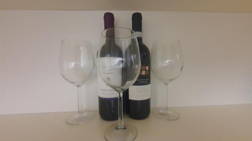 卡萨诺德莱穆尔杰MERCADANTE - Luxury Holiday House的三杯葡萄酒和一瓶葡萄酒