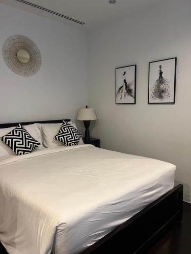 卡塔海滩卡塔花园公寓的卧室配有一张白色床,墙上挂有三张照片