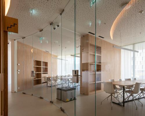 波尔图micampus Porto Tower的一间会议室,配有玻璃墙和桌椅