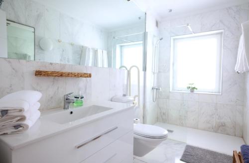 英格兰海滩Sun Club Playa del Ingles的白色的浴室设有水槽和卫生间。