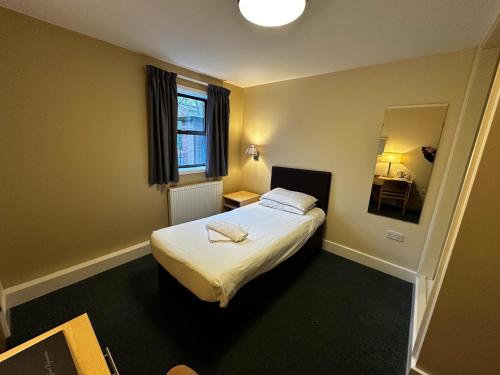 谢菲尔德威尔逊卡莱尔中心酒店的小房间设有床和镜子