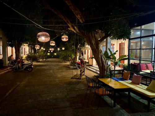 昆岛Eden House & Coffee Con Dao的庭院在晚上配有桌椅