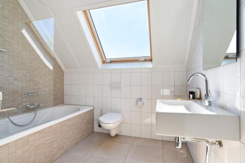 尼乌弗利特Dormio Strand Resort Nieuwvliet-Bad的浴室配有盥洗池和天窗。
