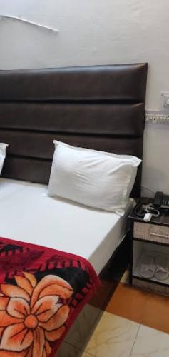 珀勒德布尔Hotel Pratap Regal,Bharatpur的一间卧室配有一张带枕头和桌子的床