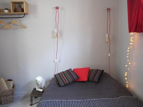 巴涅奥莱Studio avec cour extérieure的一间卧室配有一张带红色枕头和灯的床
