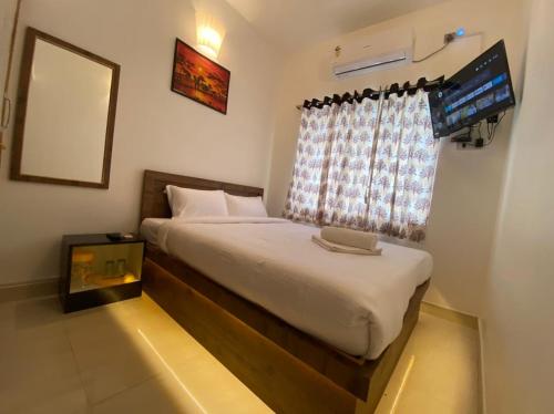 蓬蒂切里Le Poshe Luxury Pondicherry的一间卧室配有一张带笔记本电脑的床