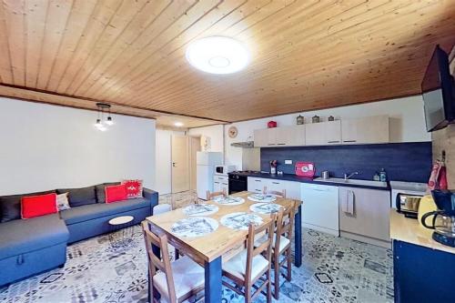 圣韦朗CASA-La Fuste center St-Véran foot of the slopes 6p的厨房以及带桌子和蓝色沙发的用餐室。