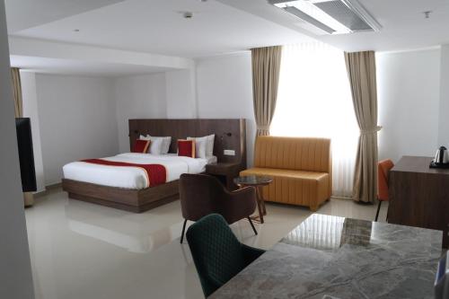 埃尔讷古勒姆Hotel Seven Lights的配有一张床和一把椅子的酒店客房