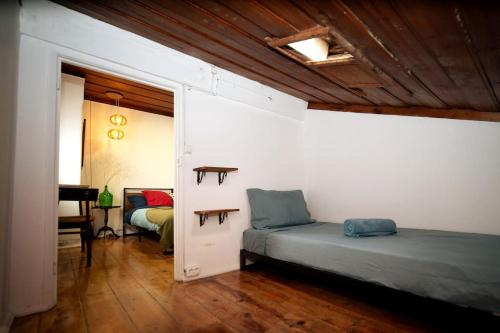 希拉自由镇Casa Pássaro的一间带两张床的卧室和一间带书桌的房间