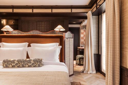 巴黎Hotel Hana的卧室配有带白色枕头的大床