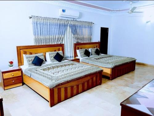 卡拉奇Galaxy Inn Guest House的一间卧室设有两张床和窗户。