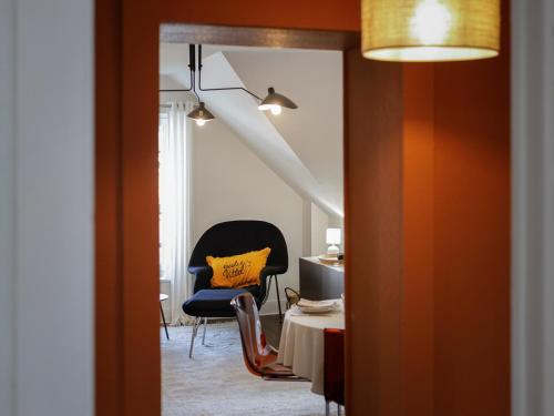 维泰勒Calme, Confort et Propreté的一间设有椅子和桌子的房间和一个黄色枕头