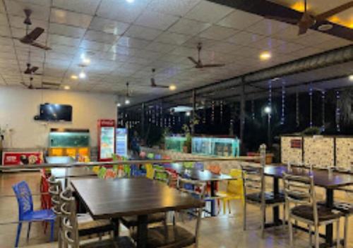 拉特纳吉里Hotel Vrindavan Ratnagiri的餐厅内带桌椅的用餐室