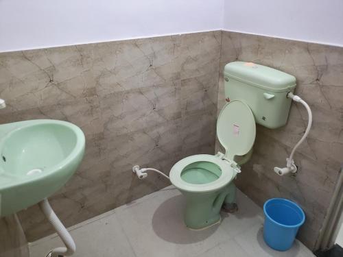 拉特纳吉里Hotel Vrindavan Ratnagiri的浴室配有绿色卫生间和水槽。