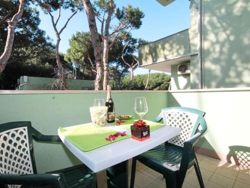 洛萨皮内塔Apartment Veranda-6 by Interhome的一张带两把椅子的白色桌子和一瓶葡萄酒