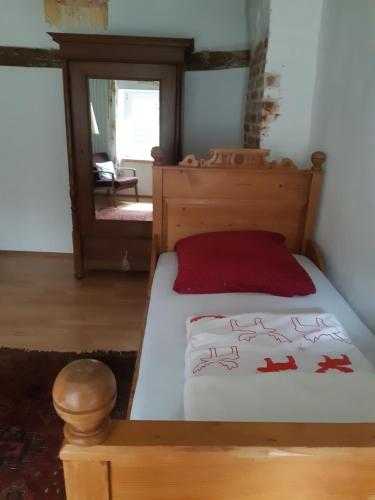 ZerfAles Ursula Sokolowski的一间卧室配有一张带红色枕头的木床