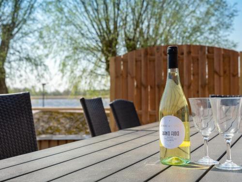 霍耶Holiday Home Gabija - all inclusive - in Western Jutland by Interhome的木桌旁的一瓶葡萄酒,带两杯