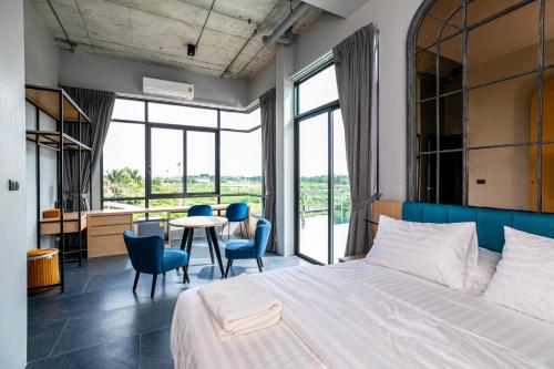 Ban Bang Bua ThongChainam-Charmchuree residences cafe and spa的卧室配有一张床和一张桌子及椅子