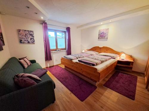 弗林肯贝格Apartment Alpina-1 by Interhome的一间卧室配有一张床、一张沙发和一个窗口