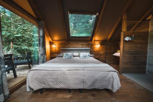 萨塞塔Glamping Pian delle Ginestre的窗户客房内的一张大床