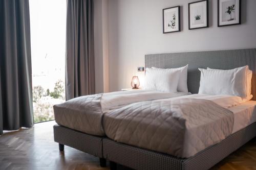 锡比乌Hermanns Hotel & Spa Sibiu的一间卧室设有一张大床和大窗户