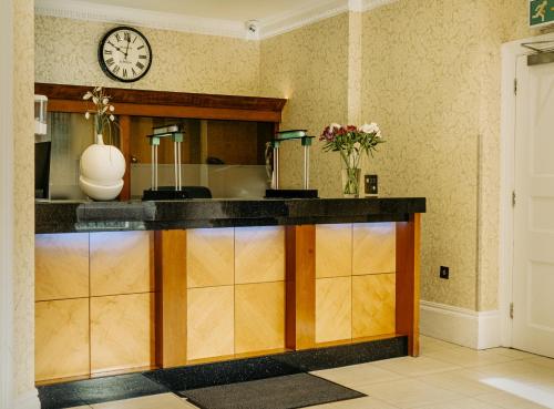 伦敦Athena Hotel的厨房配有墙上的时钟