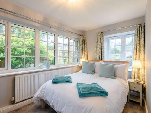 科夫堡3 Bed in Corfe Castle 81369的卧室设有一张带窗户的白色大床