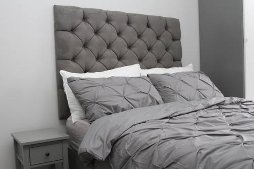伦敦New Cosy Studio in London!的一间卧室配有一张大床和软垫床头板