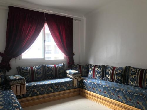 丹吉尔Appartement Tanger diari的客厅设有一张沙发,配有窗户