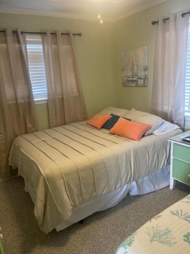 卡罗来纳比奇Bikini Bottom的一间卧室配有两张带橙色枕头的床