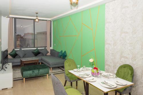 达赫拉Palm D'or-Appartement familial de luxe au centre de Dakhla的一间带桌子和沙发的用餐室