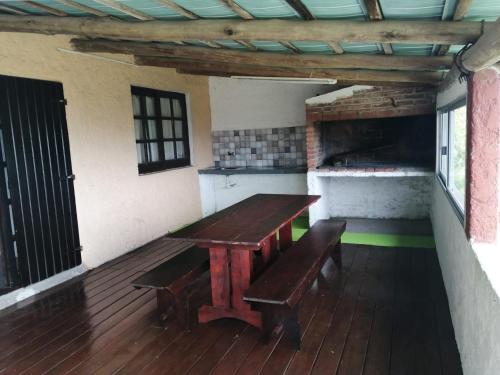 塞拉纳镇Cabaña Jacarandá的甲板上的木桌和长椅