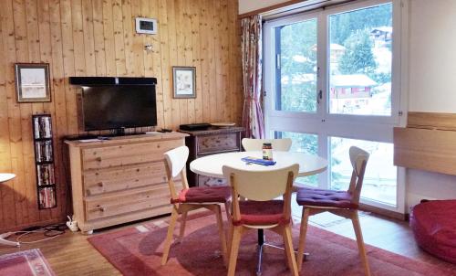 安塞热Ski-in Apartment in Anzere的客厅配有桌椅和电视。