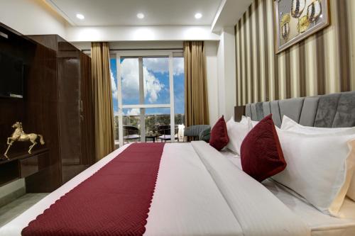 古尔冈Limewood Stay Diamond 2BHK & Studio Huda City Centre & FORTIS的一间卧室配有一张带红色和白色枕头的大床