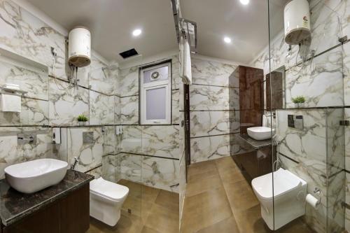 古尔冈Limewood Stay Diamond 2BHK & Studio Huda City Centre & FORTIS的浴室设有2个卫生间和玻璃淋浴间。