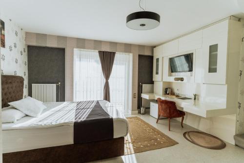 埃迪尔内Blackmoon Villa Edirne的一间卧室配有一张床、一张书桌和一个窗户。