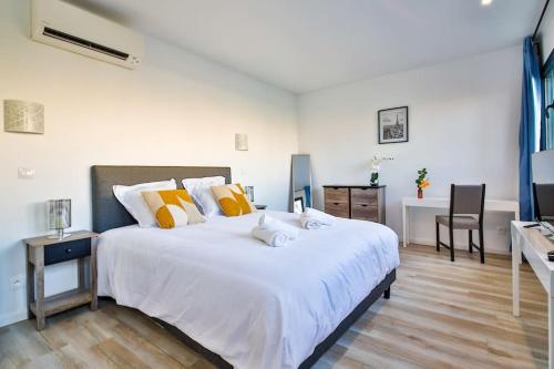 蒙鲁日Studio Design Près du Metro的卧室配有一张白色大床和一张书桌