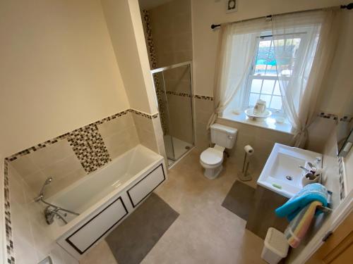 Scairbh na gCaorachPortinaghy House的带浴缸、卫生间和盥洗盆的浴室