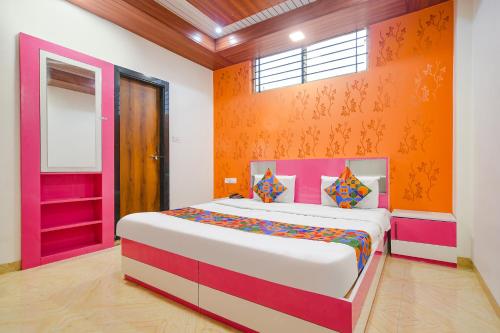 印多尔FabExpress Dream paradise的一间卧室配有一张带橙色墙壁的大床
