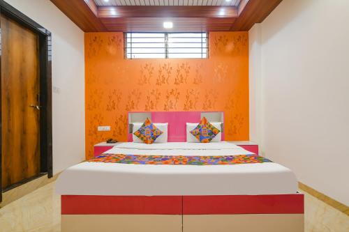 印多尔FabExpress Dream paradise的一间卧室配有一张橙色墙壁的床