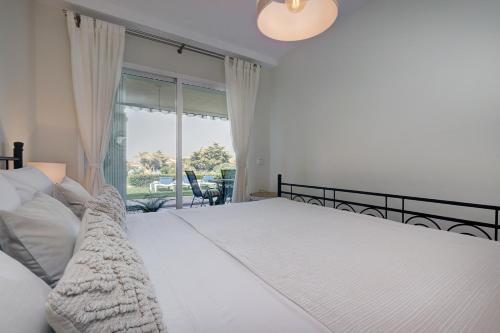 米哈斯科斯塔La Cala gorgeous 2 bedroom apartment with stunning gardens, pools and sea views的卧室设有一张白色大床和一扇窗户。