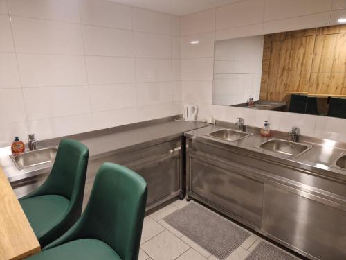 维也纳Gent Apt的浴室设有2个水槽和2把绿色椅子