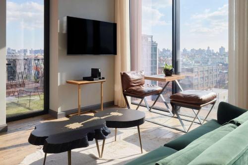 布鲁克林Arlo Williamsburg的带沙发和椅子的客厅以及大窗户。
