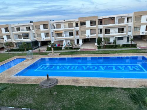 曼苏里亚Bel appartement à Malaga Beach El Mansouria的一座公寓大楼的图片,设有一个游泳池