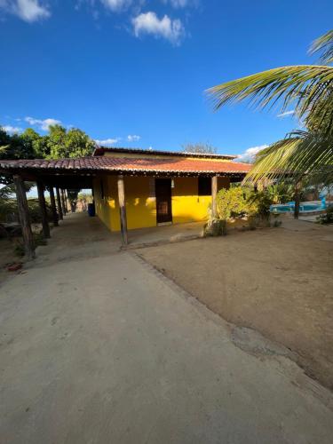 MartinsChácara Tantan - Martins RN的一座黄色房子,前面有一棵棕榈树