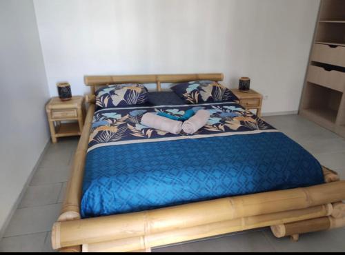 勒迪亚芒VILLA BOIS AND NATURE的一间卧室配有一张带蓝色棉被的木床