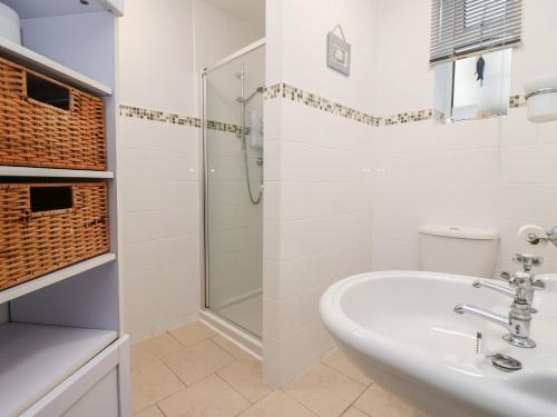 霍恩西Sea Front Apartment的带淋浴和盥洗盆的白色浴室