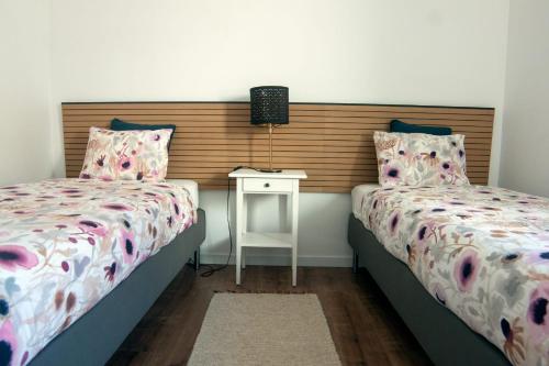 佩尼契InTune Peniche Property的一间卧室配有两张床,还有一个床头柜和一张桌子