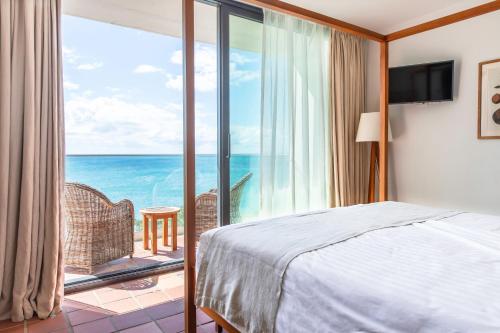 德赛Langley Resort Fort Royal的一间卧室配有一张床,享有海景