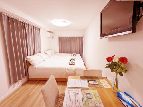 东京Rosenheim Tokyo Shinjuku Okubo的小型酒店客房配有一张床和一张桌子